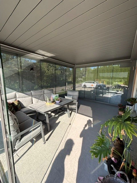 Verglaste Terrassenüberdachung bei Renate Moser mit geschlossenen Lamellen