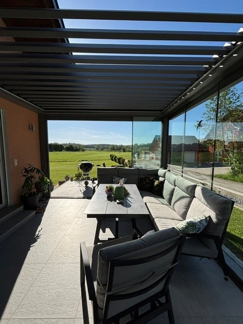 Verglaste Terrassenüberdachung bei Renate Moser mit Blick ins Grüne